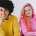Happy diverse teenagers in bright outfit smiling and looking at camera on white background of studio